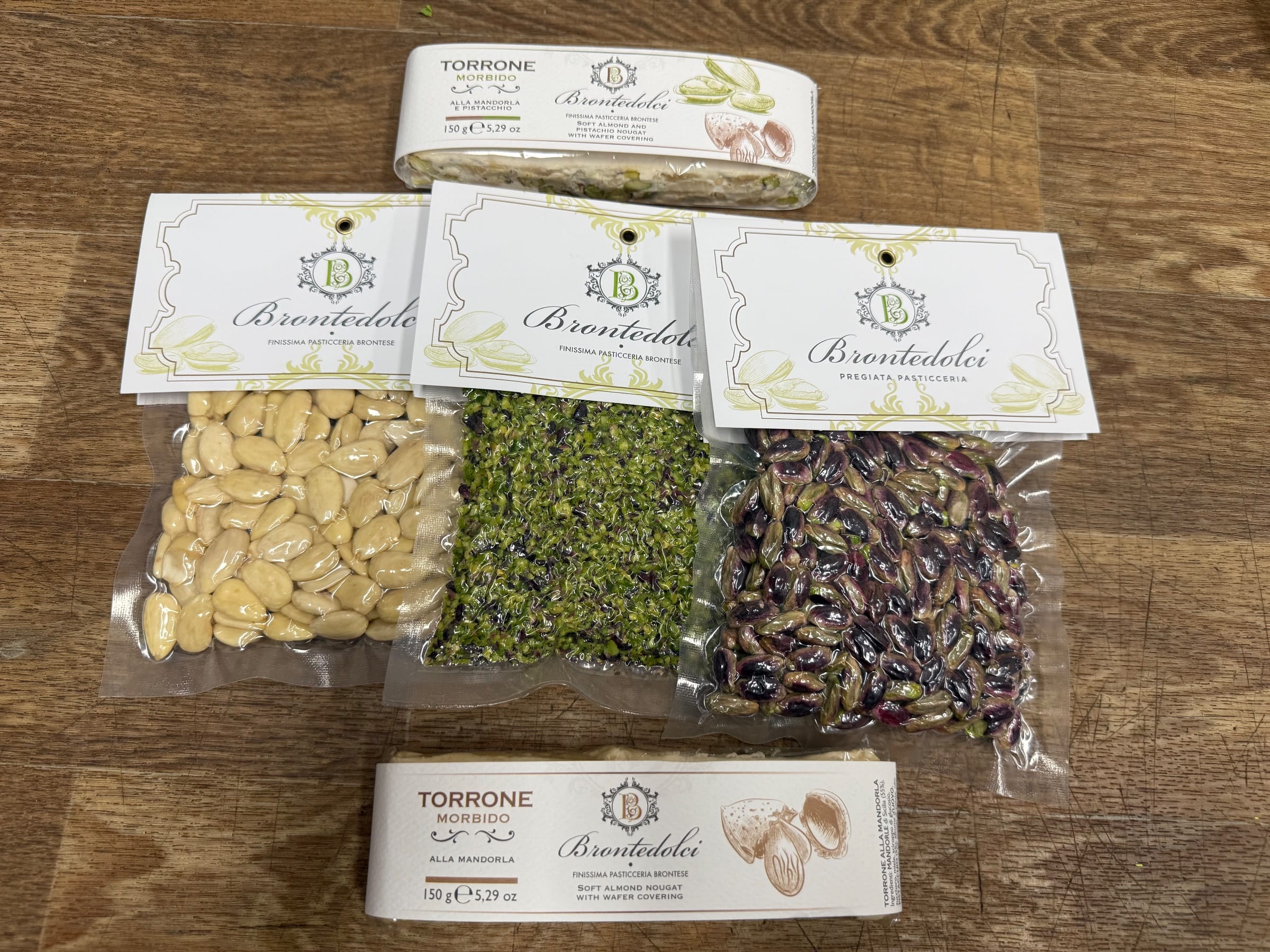 I torroni morbidi Brontedolci alla mandorla e alla mandorla e pistacchio, con i sacchetti di mandorle pelate, granella di pistacchio e pistacchi sgusciati